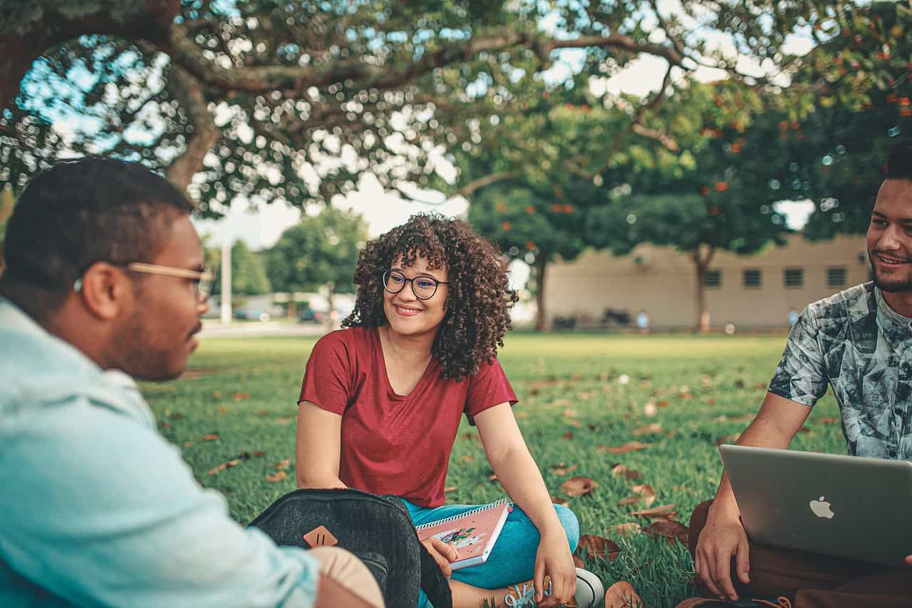 Smiling FLMMD patients relaxing in a park, happy with their Florida medical marijuana card cost