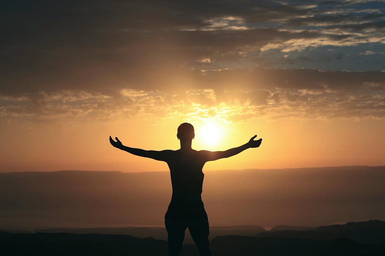Person with arms open to the sunrise, enjoying the health benefits of medical marijuana